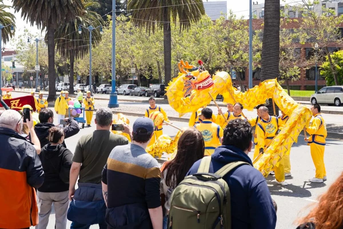 Los transeúntes observan una danza del dragón en un desfile que celebra el Día Mundial de Falun Dafa en San Francisco el 3 de mayo de 2025. (Gary Wang/The Epoch Times)