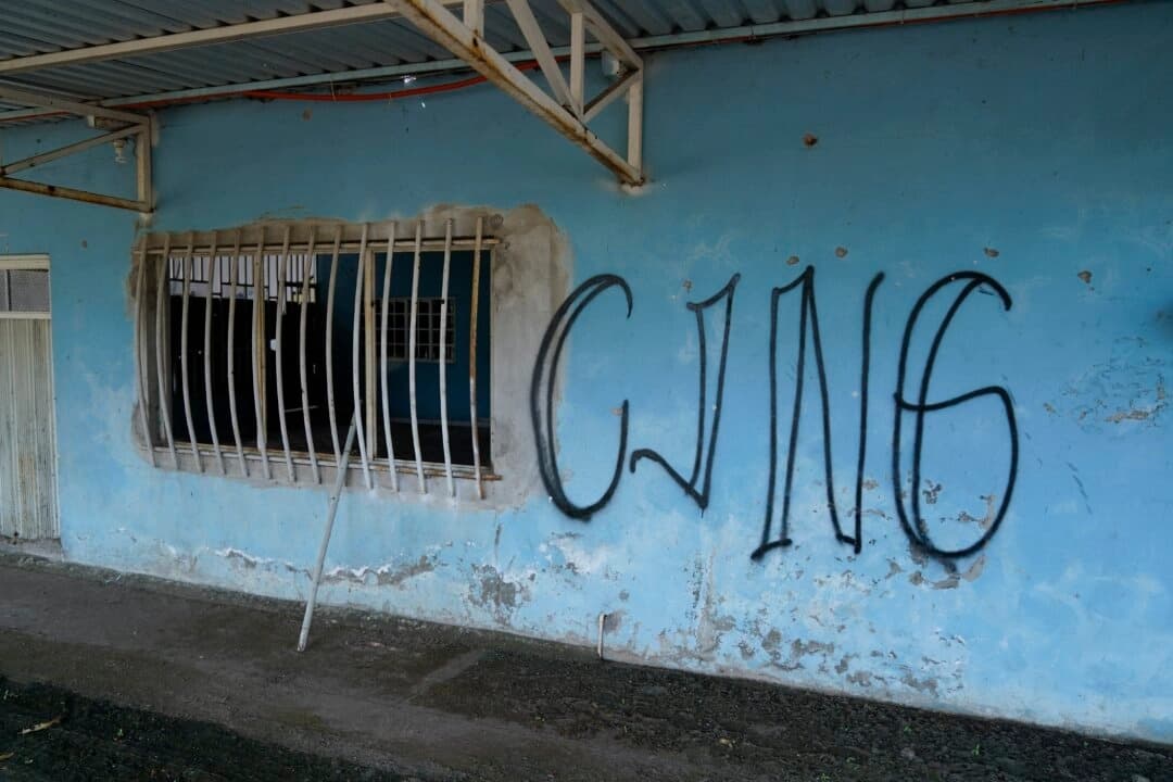Las letras «CJNG», que corresponden al nombre oficial del grupo, Cartel Jalisco Nueva Generación, están pintadas en la fachada de una casa abandonada en El Limoncito, en el estado mexicano de Michoacán, el 30 de octubre de 2021. (Eduardo Verdugo/AP Photo)
