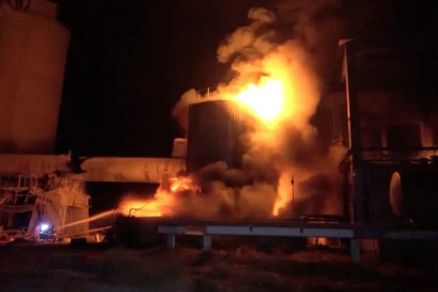 Los bomberos trabajan mientras se producen enormes incendios en una fábrica de cemento en Yemen después de que el ejército israelí anunciara que había llevado a cabo ataques aéreos contra el puerto de Hodeidah y sus alrededores, en el distrito de Bajil, provincia de Hodeidah, Yemen, el 5 de mayo de 2025 (Al-Masirah TV/Handout vía Reuters)
