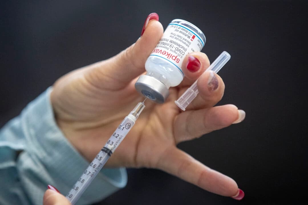 Una enfermera extrae una vacuna en una clínica de vacunación contra COVID-19 con servicio desde el coche en Kingston, Ontario, el 2 de enero de 2022. (The Canadian Press/Lars Hagberg).