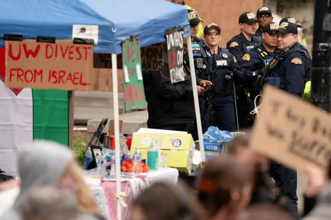 Agentes de la Patrulla Estatal de Washington observan cómo se reúnen manifestantes para protestar en apoyo de causas que incluyen a los palestinos, la inmigración, los derechos laborales y el medio ambiente, en la Universidad de Washington en Seattle, Washington, el 12 de marzo de 2025. (David Ryder/Reuters)
