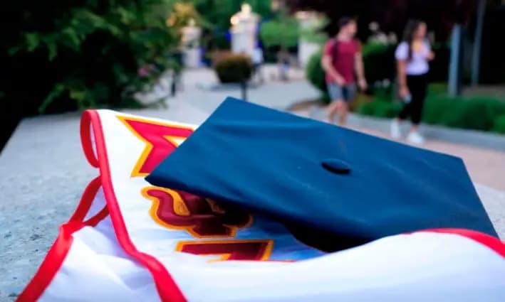 Estudiantes pasan junto a un birrete y una estola de graduación en la Universidad George Washington, en Washington, el 2 de mayo de 2022. (Stefani Reynolds/AFP vía Getty Images)