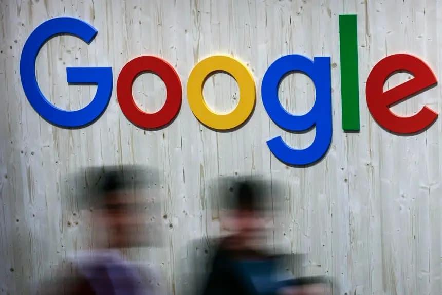 Fotografía de archivo en donde personas pasan en frente de un letrero con el logotipo de Google. EFE/Hannibal Hanschke 