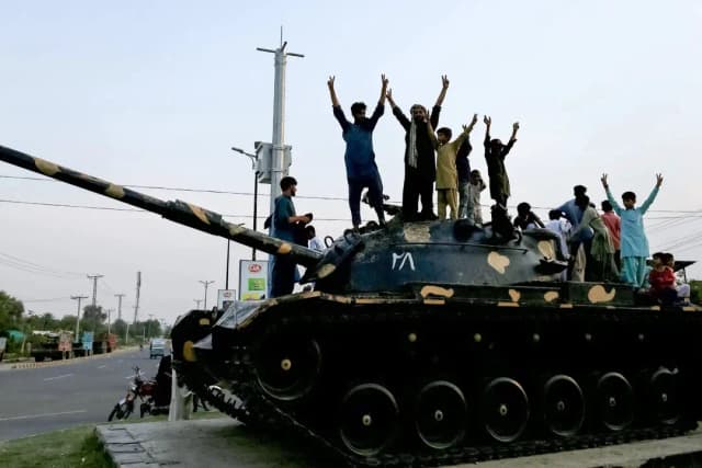 El pueblo pakistaní celebra con gestos de victoria el alto el fuego entre Pakistán y la India, en Multán, el 10 de mayo de 2025. (Shahid Saeed Mirza/AFP a través de Getty Images)
