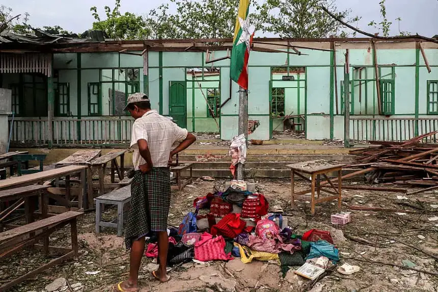 Un hombre se encuentra frente a un edificio escolar dañado en un bombardeo llevado a cabo por el ejército de Myanmar en la aldea Ohe Htein Twin, en el municipio de Tabayin, región de Sagaing, el 12 de mayo de 2025. (AFP vía Getty Images)