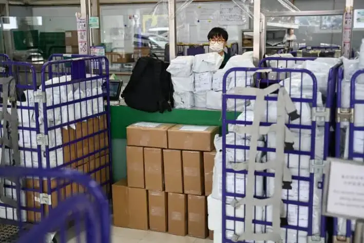 Un empleado del Hong Kong Post se encuentra en un mostrador de servicio en una oficina de correos en Hong Kong, el 16 de abril de 2025. (Peter Parks/AFP vía Getty Images)
