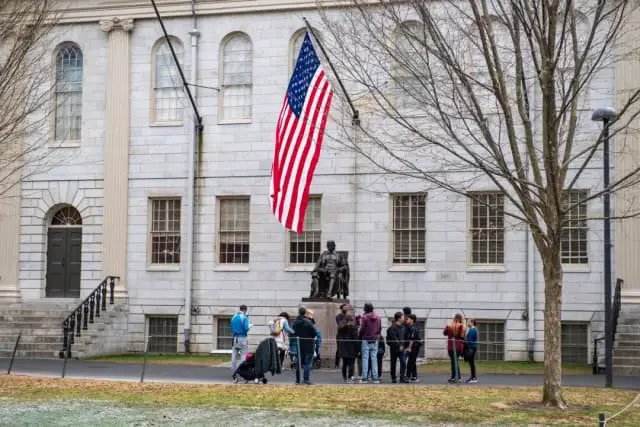 La gente se reúne alrededor de la estatua de John Harvard en el campus de la Universidad de Harvard en Cambridge, Massachusetts, el 15 de abril de 2025. (Joseph Prezioso/AFP a través de Getty Images)
