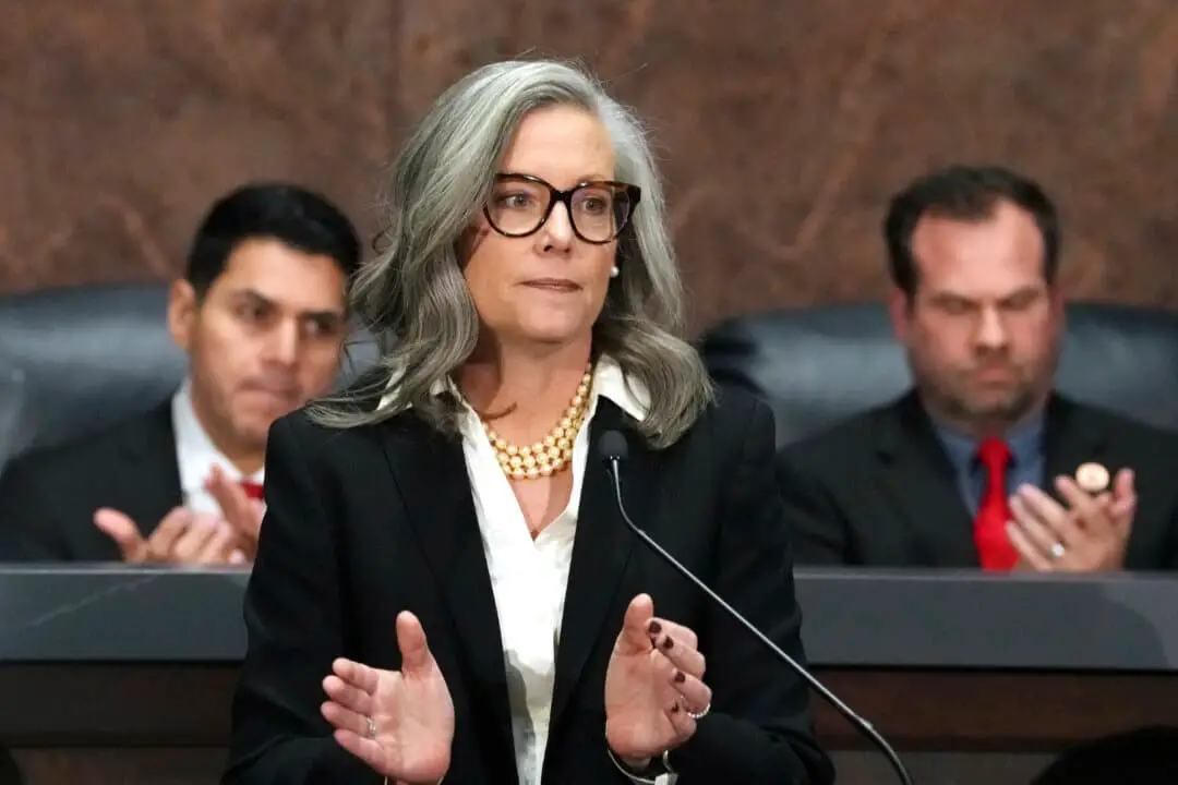 La gobernadora de Arizona, Katie Hobbs (C), aplaude en apoyo a los afectados por los incendios forestales en el área de Los Ángeles mientras pronuncia el discurso del Estado sobre el Estado en la Cámara de Representantes del Capitolio, flanqueada por el presidente de la Cámara, Steve Montenegro (I), y el presidente del Senado, Warren Petersen (D), en Phoenix, el 13 de enero de 2025. (Ross D. Franklin / Archivo de AP)