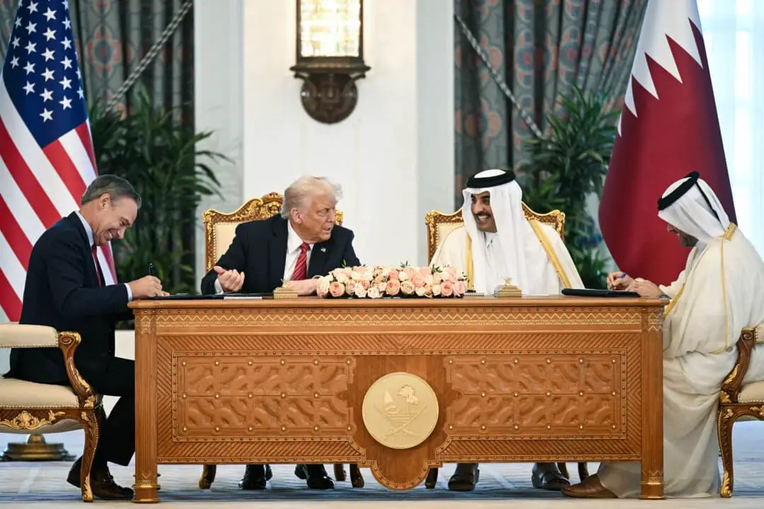 El director ejecutivo de Boeing, Kelly Ortberg, sentado a la izquierda del presidente Donald Trump y el emir de Catar, el jeque Tamim bin Hamad al-Thani (derecha), durante la ceremonia de firma de un acuerdo comercial en el Palacio Real de Doha, Catar, el 14 de mayo de 2025. (Brendan Smialowski/AFP a través de Getty Images)