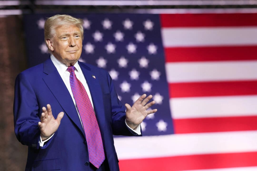 El presidente Donald Trump hace un gesto en el escenario mientras recorre la base aérea Al Udeid, en Doha, Qatar, el 15 de mayo de 2025. (Win McNamee/Getty Images)