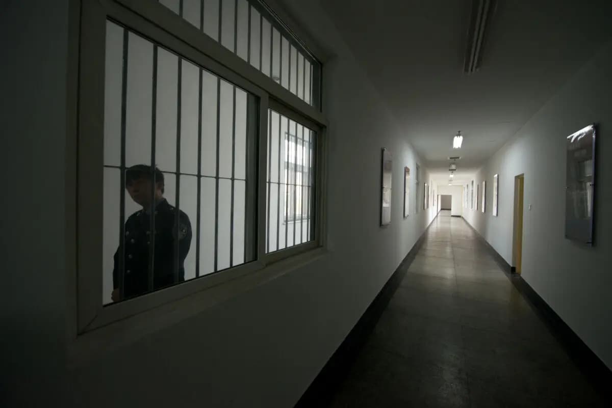 Un guardia mira a través de la ventana de un pasillo dentro de un centro de detención en Beijing, China, el 25 de octubre de 2012. (Ed Jones/AFP vía Getty Images).