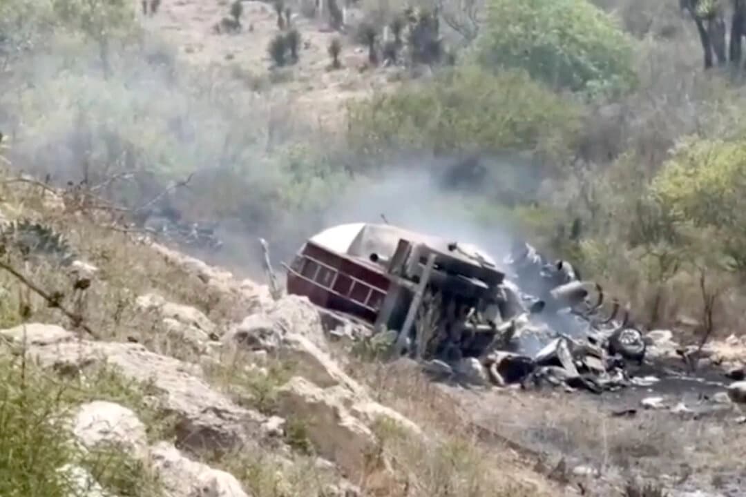 Un camión volcado y quemado al borde de una carretera en Puebla, México, el 14 de mayo de 2025, en una imagen fija de un vídeo. (Reuters/Captura de pantalla vía The Epoch Times).