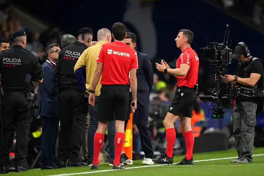 El árbitro César Soto Grado habla con los agentes de policía en la línea de banda durante una pausa en el juego durante el partido de LaLiga entre el RCD Espanyol de Barcelona y el FC Barcelona en el estadio RCDE el 15 de mayo de 2025 en Barcelona, ​​​​España. (Alex Caparros/Getty Images)