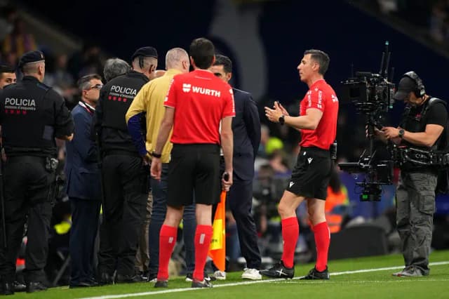 El árbitro César Soto Grado habla con los agentes de policía en la línea de banda durante una pausa en el juego durante el partido de LaLiga entre el RCD Espanyol de Barcelona y el FC Barcelona en el estadio RCDE el 15 de mayo de 2025 en Barcelona, ​​​​España. (Alex Caparros/Getty Images)