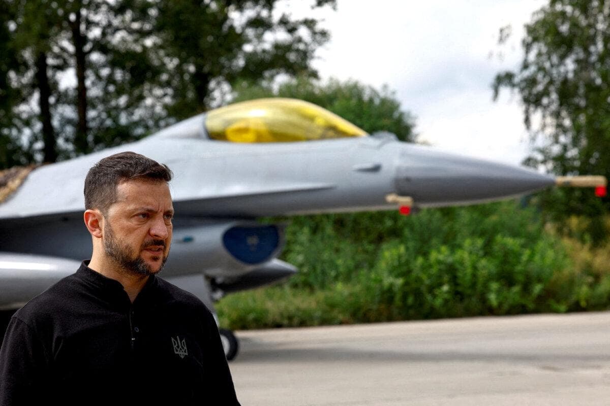 El presidente ucraniano, Volodímir Zelenski, junto a un caza F-16 en un lugar no revelado de Ucrania, el 4 de agosto de 2024. (Valentyn Ogirenko/Reuters)