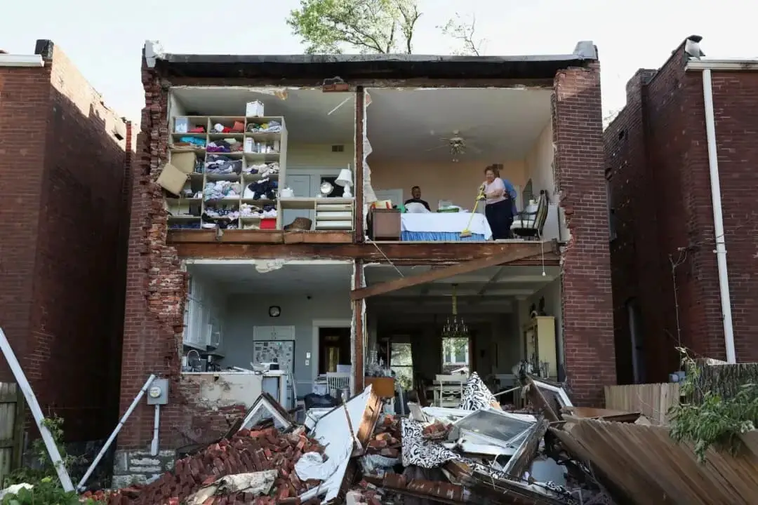 Residentes inspeccionan su vivienda después de que un tornado arrancara la pared trasera de una casa en St. Louis, Mo., el 16 de mayo de 2025. (Lawrence Bryant/Reuters)
