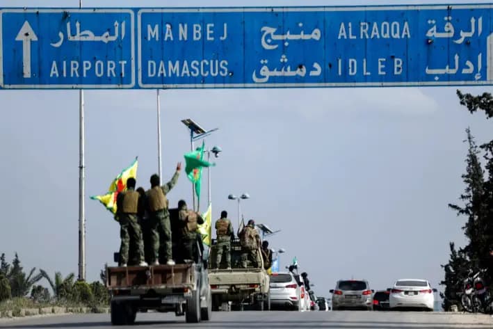 Combatientes kurdos respaldados por Estados Unidos se encuentran en sus vehículos mientras se retiran de dos barrios de la ciudad de Alepo, en el norte de Siria, como parte de un acuerdo con el gobierno central sirio, en Alepo, Siria, el 4 de abril de 2025. (Foto AP/Ghaith Alsayed)