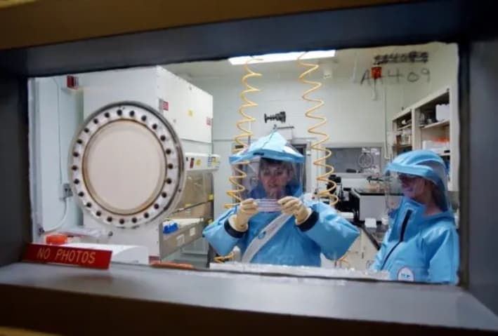 Personal trabajando en el laboratorio de bioseguridad de nivel 4 del Instituto de Investigación Médica de Enfermedades Infecciosas del Ejército de Estados Unidos en Fort Detrick, Maryland, el 26 de septiembre de 2002. (Olivier Douliery/AFP a través de Getty Images)