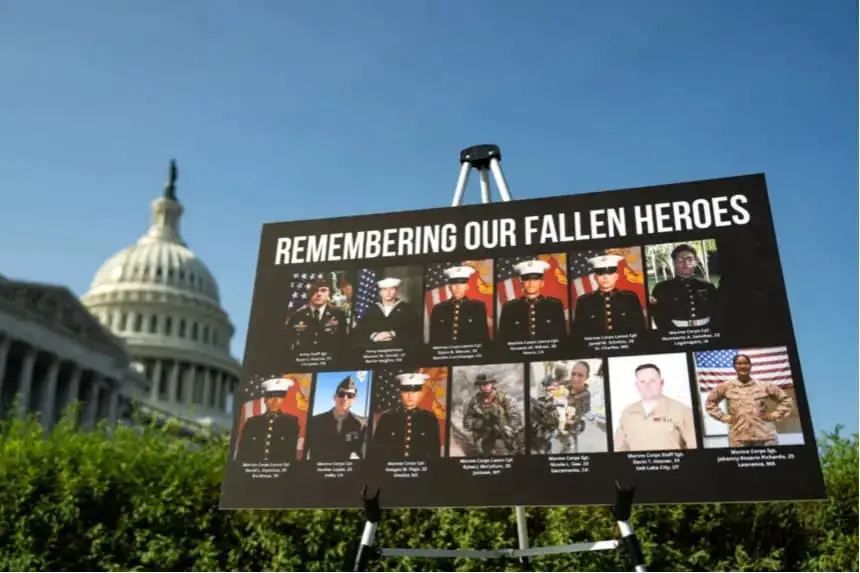 Un cartel con fotos y nombres de los 13 militares asesinados en un ataque terrorista en Abbey Gate, afuera del Aeropuerto Internacional Hamid Karzai de Kabul, se ve durante una conferencia de prensa en el Capitolio de los Estados Unidos en Washington el 9 de septiembre de 2024. (Kent Nishimura/Getty Images)