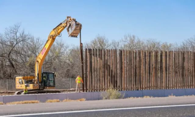 Obreros de la construcción colocan un bolardo a lo largo del muro fronterizo en Eagle Pass, Texas, el 25 de enero de 2022. (Charlotte Cuthbertson/The Epoch Times)
