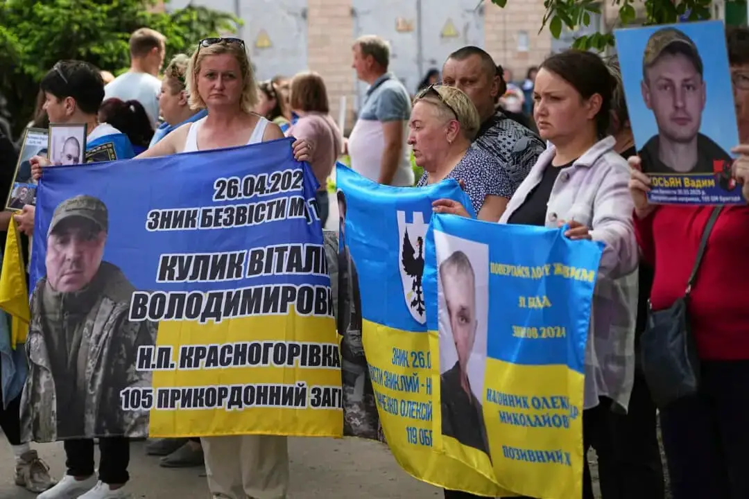 Familiares de prisioneros ucranianos sostienen pancartas y fotos de militares cautivos antes de un intercambio de prisioneros entre Rusia y Ucrania, en la región de Chernihiv, Ucrania, el 23 de mayo de 2025. (Efrem Lukatsky/AP Photo)