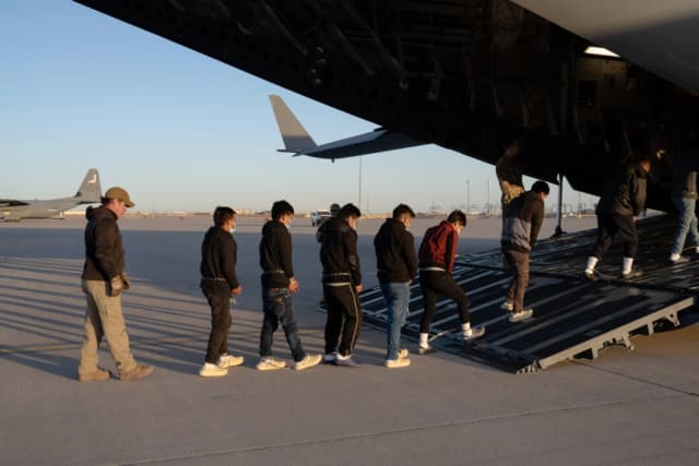 Agentes de seguridad de la Oficina de Aduanas y Protección Fronteriza de Estados Unidos guían a inmigrantes ilegales a bordo de un C-17 Globemaster III para un vuelo de expulsión en Fort Bliss, Texas, el 23 de enero de 2025. (Foto del Departamento de Defensa tomada por el sargento de primera clase del Ejército de Estados Unidos Nicholas J. De La Pena)