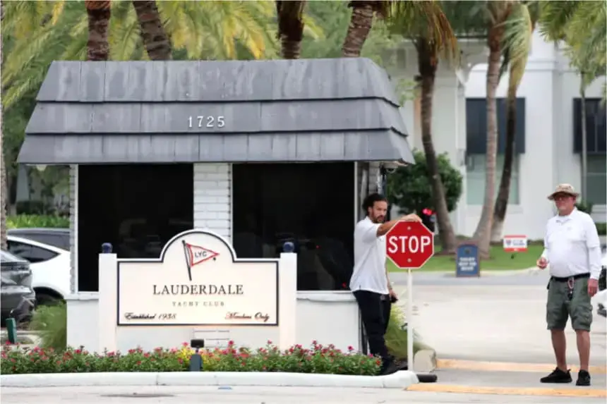 Dos hombres hacen guardia frente al Fort Lauderdale Yacht Club después de la explosión de un barco cerca del club, en Fort Lauderdale, Florida, el 26 de mayo de 2025. (Carline Jean/South Florida Sun Sentinel vía AP)