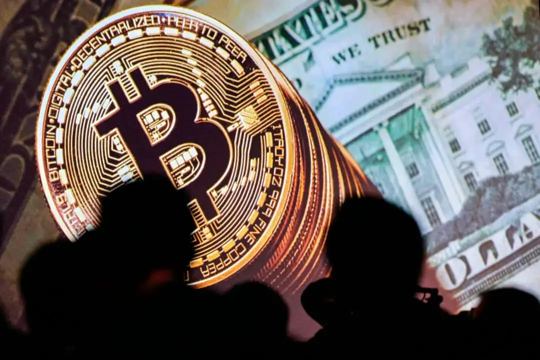 Bitcoin y las divisas estadounidenses se muestran en una pantalla mientras los delegados escuchan a los ponentes durante el Congreso Mundial de Interpol en Singapur el 4 de julio de 2017. (Dominic Gwinn/AFP a través de Getty Images)

