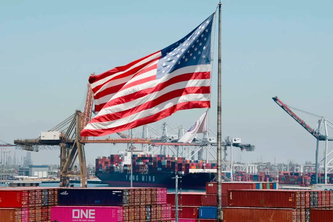 La bandera estadounidense ondea sobre un buque portacontenedores que descarga su mercancía procedente de Asia en el puerto de Long Beach, California, el 1 de agosto de 2019. (Mark Ralston/AFP a través de Getty Images).