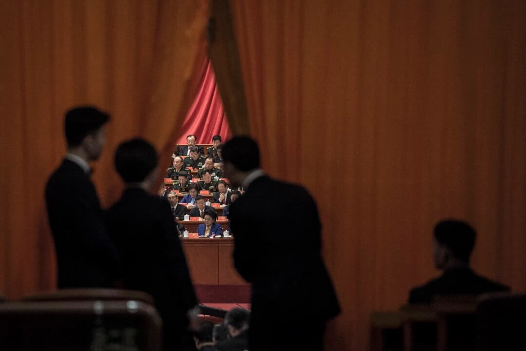 Guardias de seguridad chinos observan a los delegados militares durante el discurso del líder chino Xi Jinping en el XIX Congreso del Partido Comunista en Pekín, el 18 de octubre de 2017. (Fred Dufour/AFP a través de Getty Images).