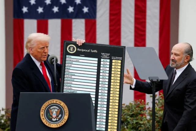 El presidente Donald Trump sostiene un gráfico junto al secretario de Comercio, Howard Lutnick (derecha), mientras Trump pronuncia unas palabras sobre los aranceles en el Jardín de las Rosas de la Casa Blanca, en Washington, el 2 de abril de 2025. (Carlos Barria/Reuters)
