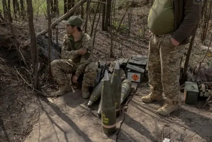 Militares ucranianos de la unidad de artillería del regimiento Skala esperan junto a proyectiles mientras sus compañeros disparan un obús M109 hacia posiciones rusas, en una zona no revelada, en la región oriental de Donetsk, el 23 de abril de 2025. (Roman Pilipey/ AFP vía Getty Images)