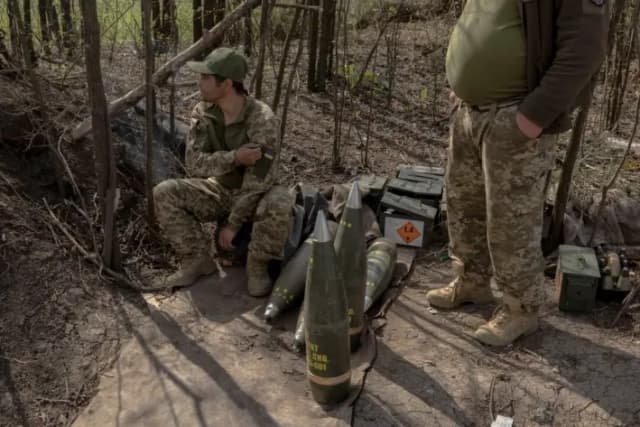 Militares ucranianos de la unidad de artillería del regimiento Skala esperan junto a proyectiles mientras sus compañeros disparan un obús M109 hacia posiciones rusas, en una zona no revelada, en la región oriental de Donetsk, el 23 de abril de 2025. (Roman Pilipey/ AFP vía Getty Images)
