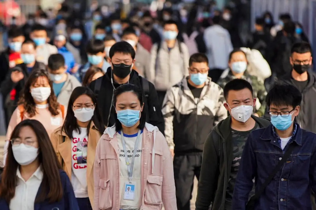 Los viajeros llevan mascarillas protectoras al salir de un tren en una estación de metro durante la hora pico del lunes en Beijing, China, el 13 de abril de 2020. (Lintao Zhang/Getty Images)