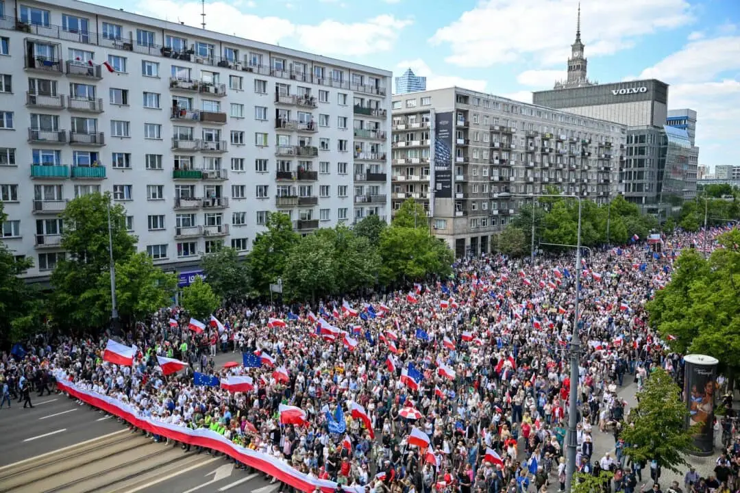 Partidarios del candidato presidencial polaco Rafal Trzaskowski, también alcalde de Varsovia y miembro del partido gobernante centrista Coalición Cívica, ondean banderas de Polonia y la Unión Europea (UE) mientras caminan por las calles durante un mitin de campaña en Varsovia, el 25 de mayo de 2025. (Sergei Gapon/AFP vía Getty Images)