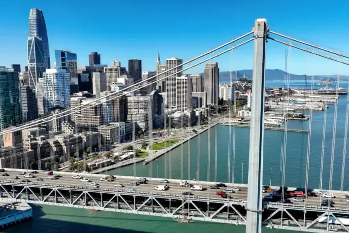 En una vista aérea, los automóviles pasan junto al horizonte de San Francisco al cruzar el puente de la bahía de San Francisco-Oakland, el 27 de octubre de 2022. (Justin Sullivan/Getty Images)