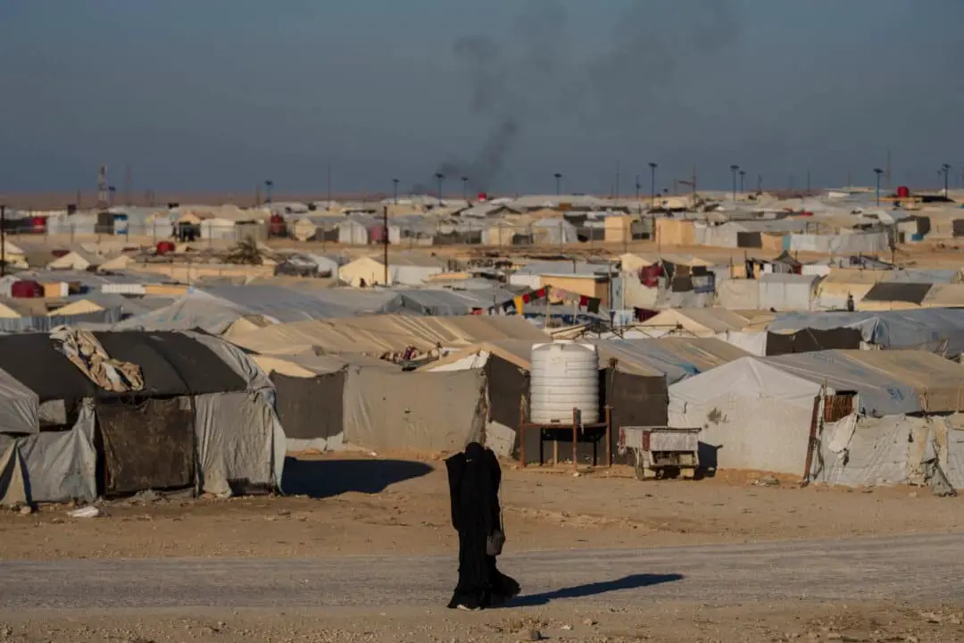 Una mujer camina por el campo de al-Hol, en la provincia de Hasakeh, al noreste de Siria, donde desde hace años viven decenas de miles de personas, en su mayoría mujeres y niños vinculados al grupo terrorista ISIS, el 30 de enero de 2025. (Bernat Armangue/AP Photo).