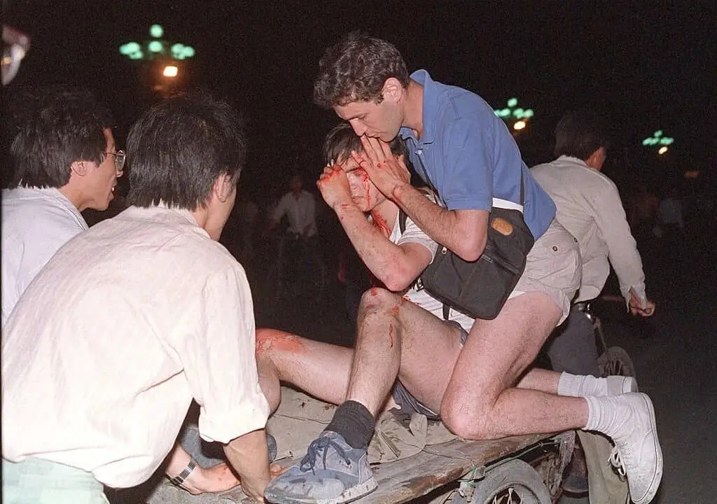 Un periodista extranjero no identificado (segundo por la derecha) es sacado del lugar del enfrentamiento entre el ejército y los estudiantes cerca de la plaza de Tiananmen, en Beijing, el 4 de junio de 1989. (Tommy Cheng/AFP/Getty Images).