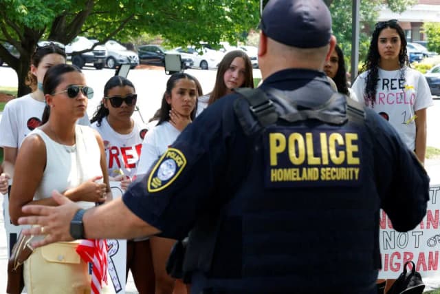 Un agente de Seguridad Nacional habla con los compañeros de clase y familiares de Marcelo Gomes da Silva reunidos frente al tribunal de inmigración en Chelmsford, Massachusetts, el 5 de junio de 2025. (Brian Snyder/Reuters)