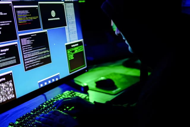 En esta ilustración fotográfica, un hacker escribe en el teclado de un ordenador el 13 de mayo de 2025. (Anna Varavva/The Epoch Times)