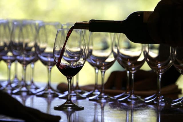 Un trabajador de una bodega sirve una copa de vino para una cata en Rutherford, California, en esta foto de archivo. (Justin Sullivan/Getty Images)