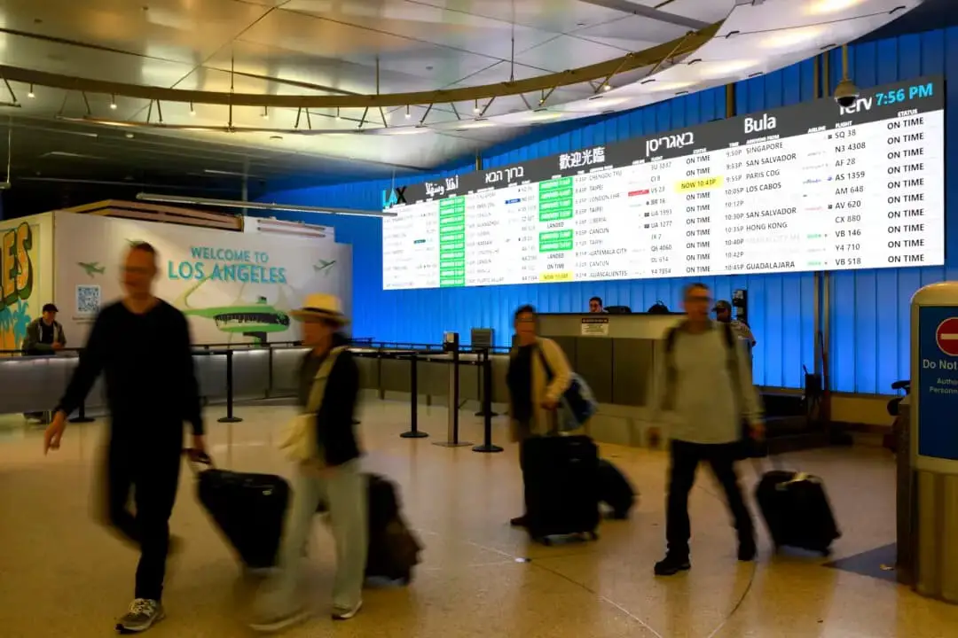 Viajeros transportan su equipaje por la zona de llegadas internacionales del Aeropuerto Internacional de Los Ángeles, en Los Ángeles, el 8 de junio de 2025. (William Liang/AP Photo)