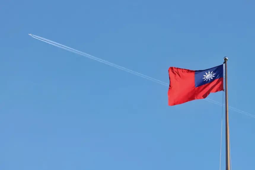 Un avión sobrevuela la bandera nacional de Taiwán, que ondea al viento en el Bulevar de la Democracia, en Taipéi, el 15 de octubre de 2024. (I-Hwa Cheng/AFP vía Getty Images)