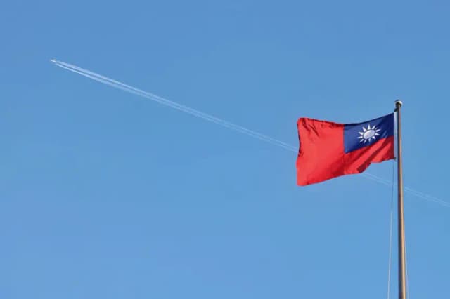 Un avión sobrevuela la bandera nacional de Taiwán, que ondea al viento en el Bulevar de la Democracia, en Taipéi, el 15 de octubre de 2024. (I-Hwa Cheng/AFP vía Getty Images)