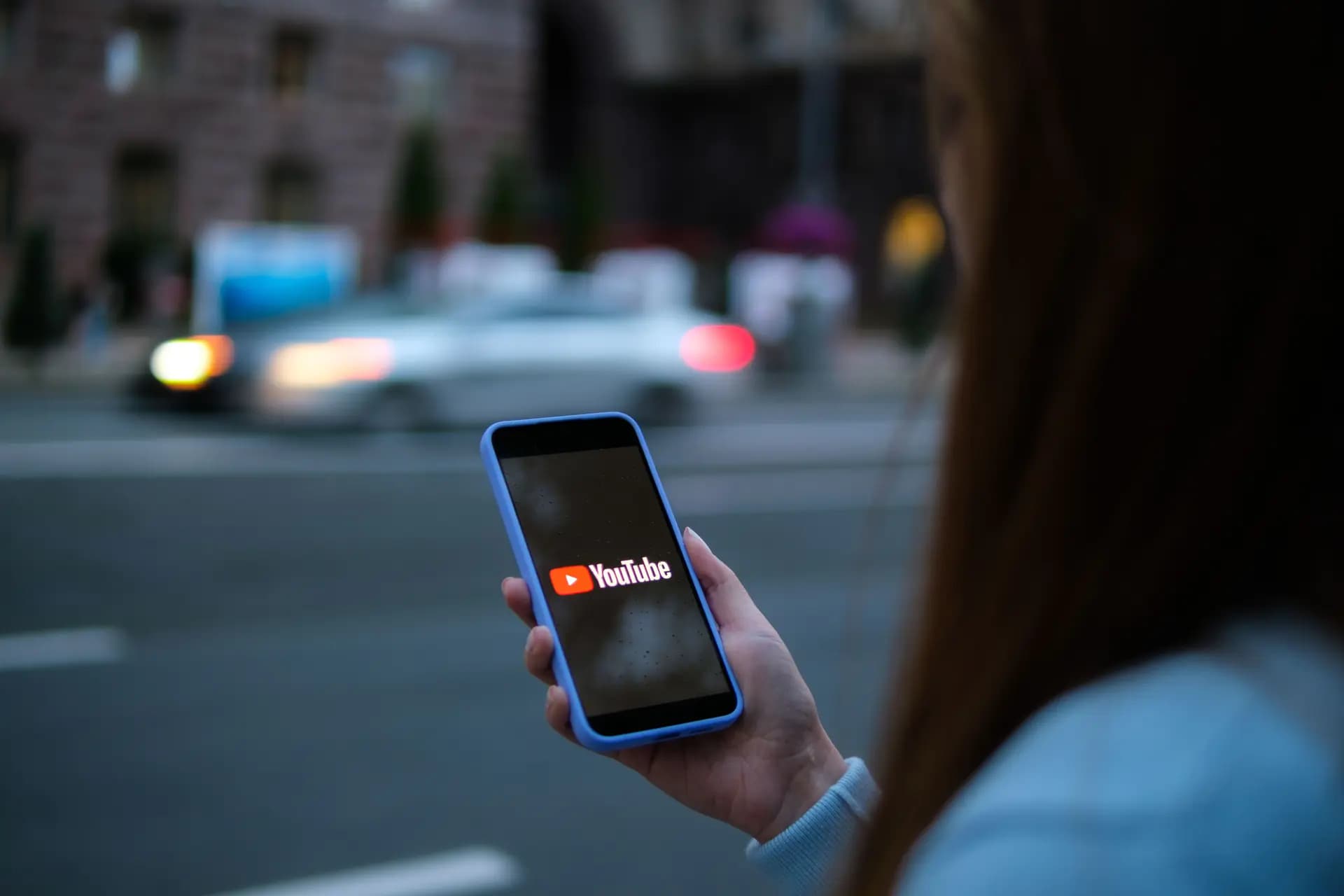 En esta foto de archivo, una mujer sostiene un teléfono en el que se ve la aplicación YouTube. En los últimos años han aparecido en la plataforma decenas de vídeos en inglés contra Falun Gong. Según denunciantes, las autoridades de seguridad pública chinas han ordenado a los youtubers que apoyen los ataques contra Falun Gong y Shen Yun. (Oleksii Pydsosonnii/The Epoch Times).