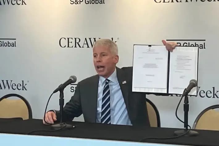 El secretario de Energía, Chris Wright, exhibe la orden que firmó en marzo, aprobando el permiso de Delfin LNG LLC para comenzar a exportar GNL desde su terminal marítima de Luisiana, durante una conferencia sobre petróleo y gas en Houston. (John Haughey/The Epoch Times)