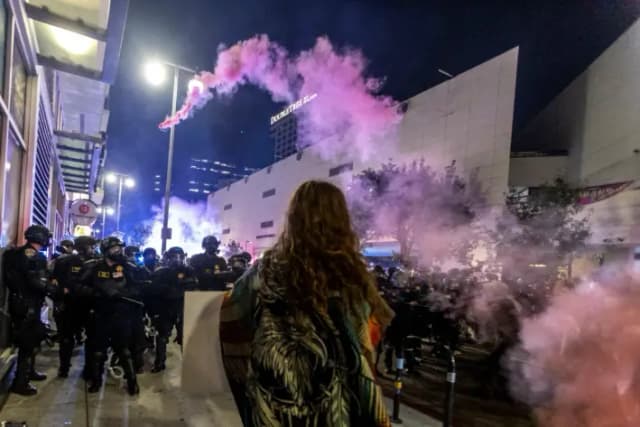 Una bomba de humo se arquea sobre una línea policial, en Los Ángeles, el 9 de junio de 2025. (Ringo Chiu/AFP vía Getty Images)