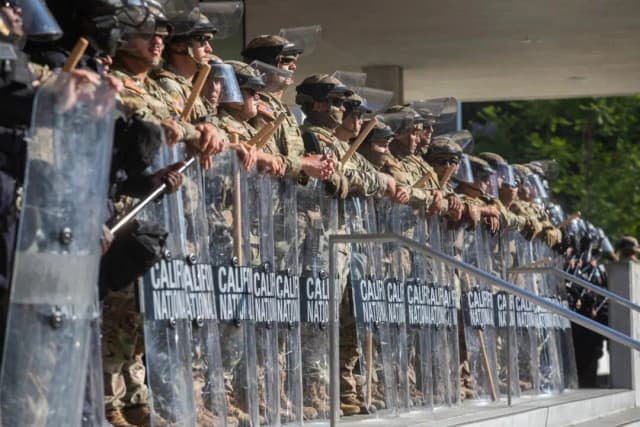 Miembros de la Guardia Nacional de California montan guardia frente al edificio federal mientras continúan las protestas en respuesta a las operaciones federales de inmigración en Los Ángeles, el 10 de junio de 2025. (Apu Gomes/AFP a través de Getty Images)
