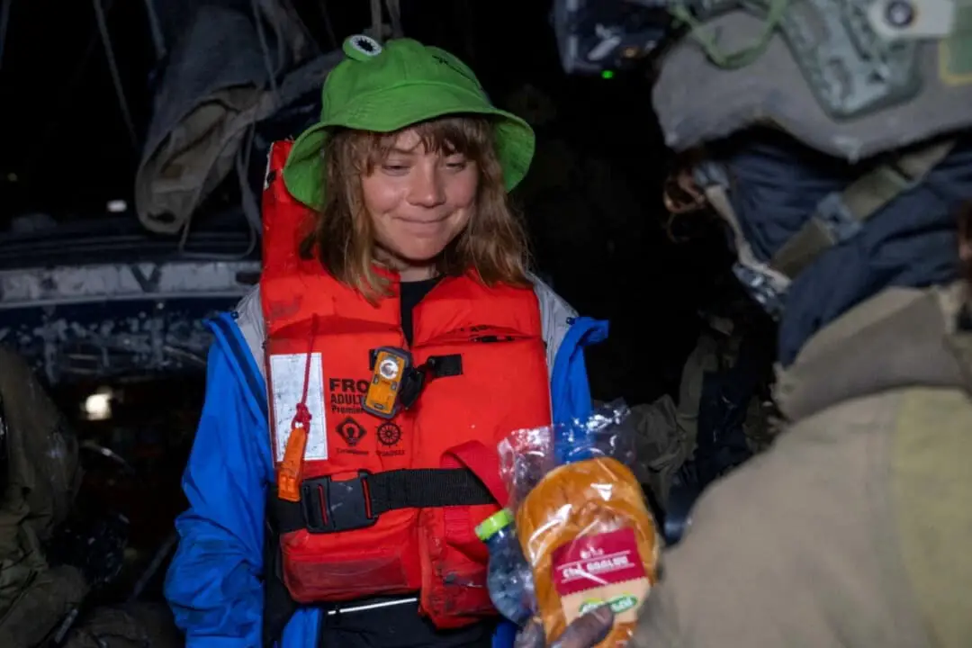 Un soldado israelí le pasa un bollo a Greta Thunberg a bordo del yate de bandera británica «Madleen», con destino a Gaza, después de que las fuerzas israelíes abordaran el barco benéfico cuando intentaba llegar a la Franja de Gaza desafiando el bloqueo naval israelí, en esta imagen fija publicada el 9 de junio de 2025. (Ministerio de Asuntos Exteriores de Israel a través de X/Handout vía Reuters)