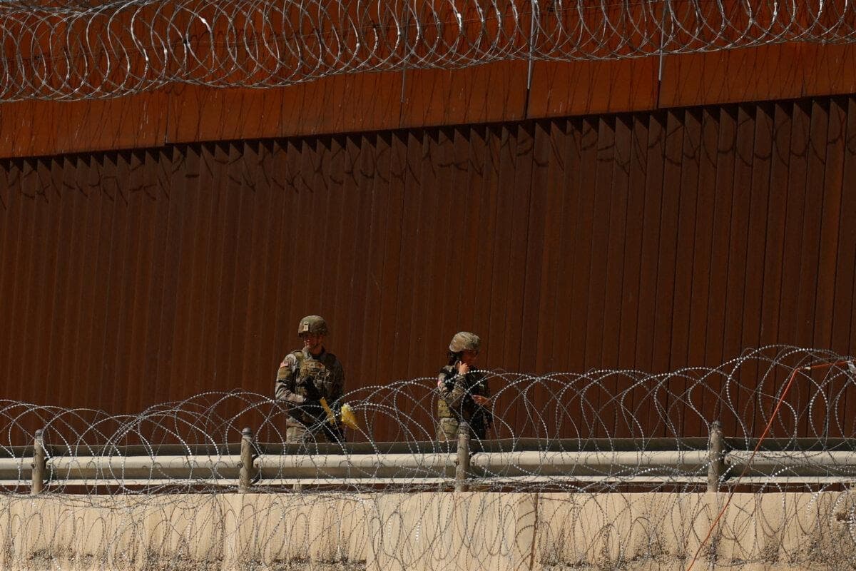 Soldados de la Guardia Nacional de Texas caminan cerca del muro fronterizo entre Estados Unidos y México, visto desde Ciudad Juárez, México, el 11 de marzo de 2025. (José Luis González/Reuters)